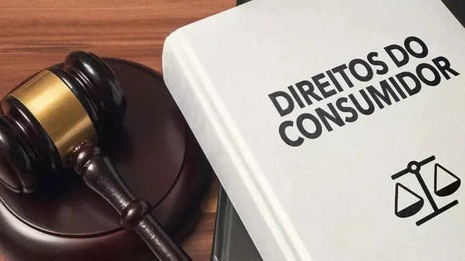Exemplar do Código de Defesa do Consumidor ao lado de um martelo de juiz